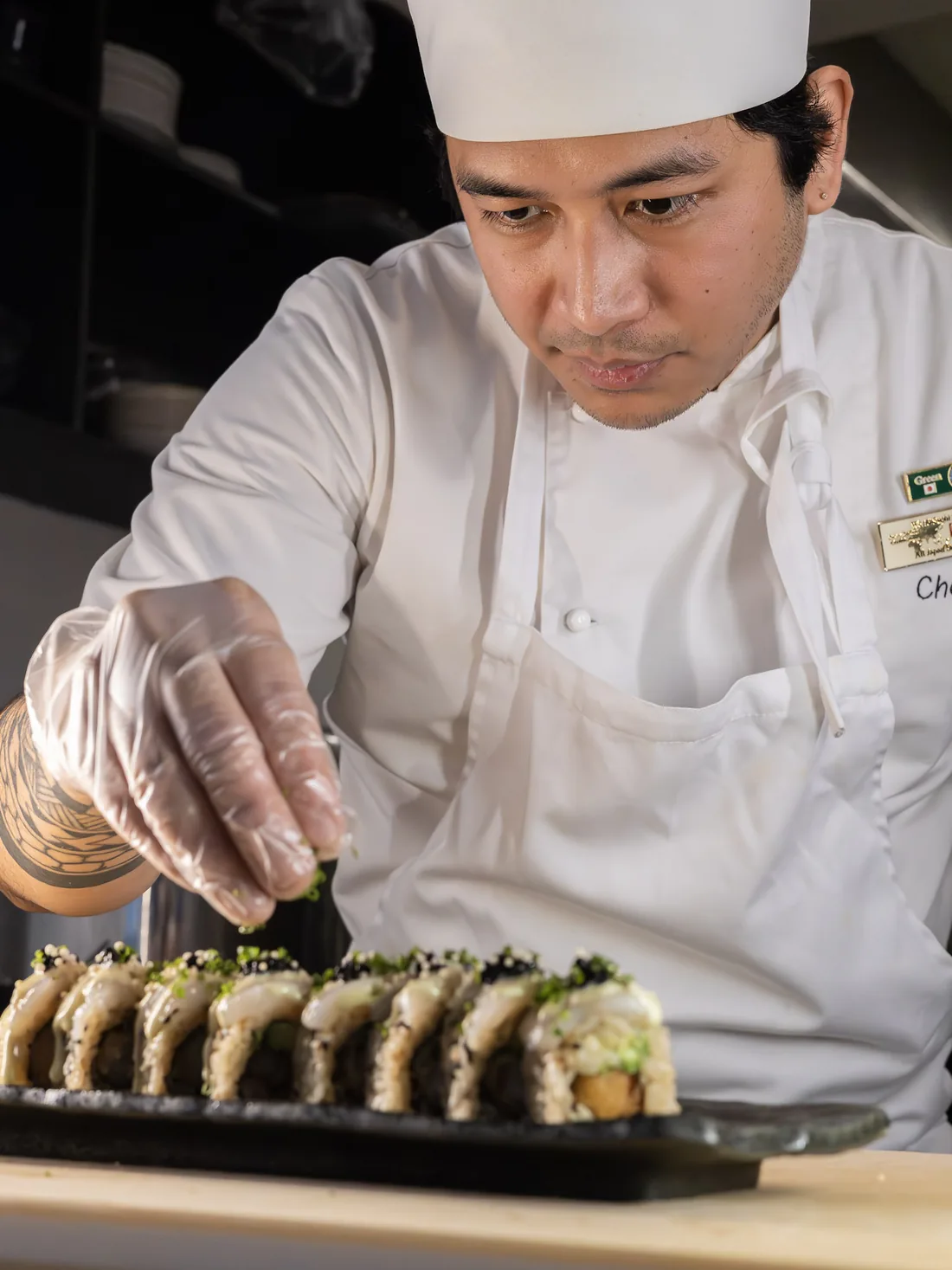 Kokk hos Sushi Roll Sandviken plasserer en rull